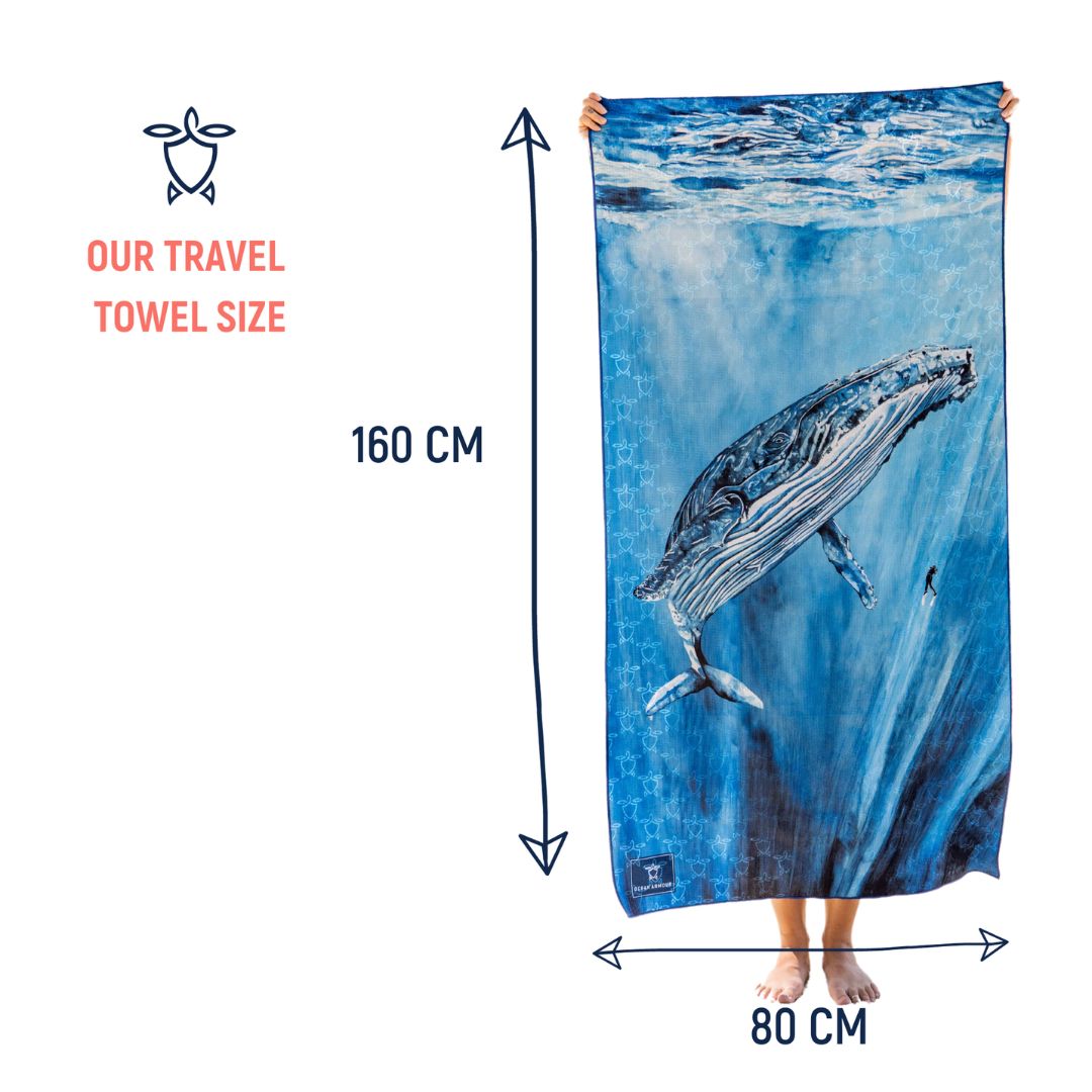 Towel with whale design held by a person, showing size 160 cm x 80 cm.