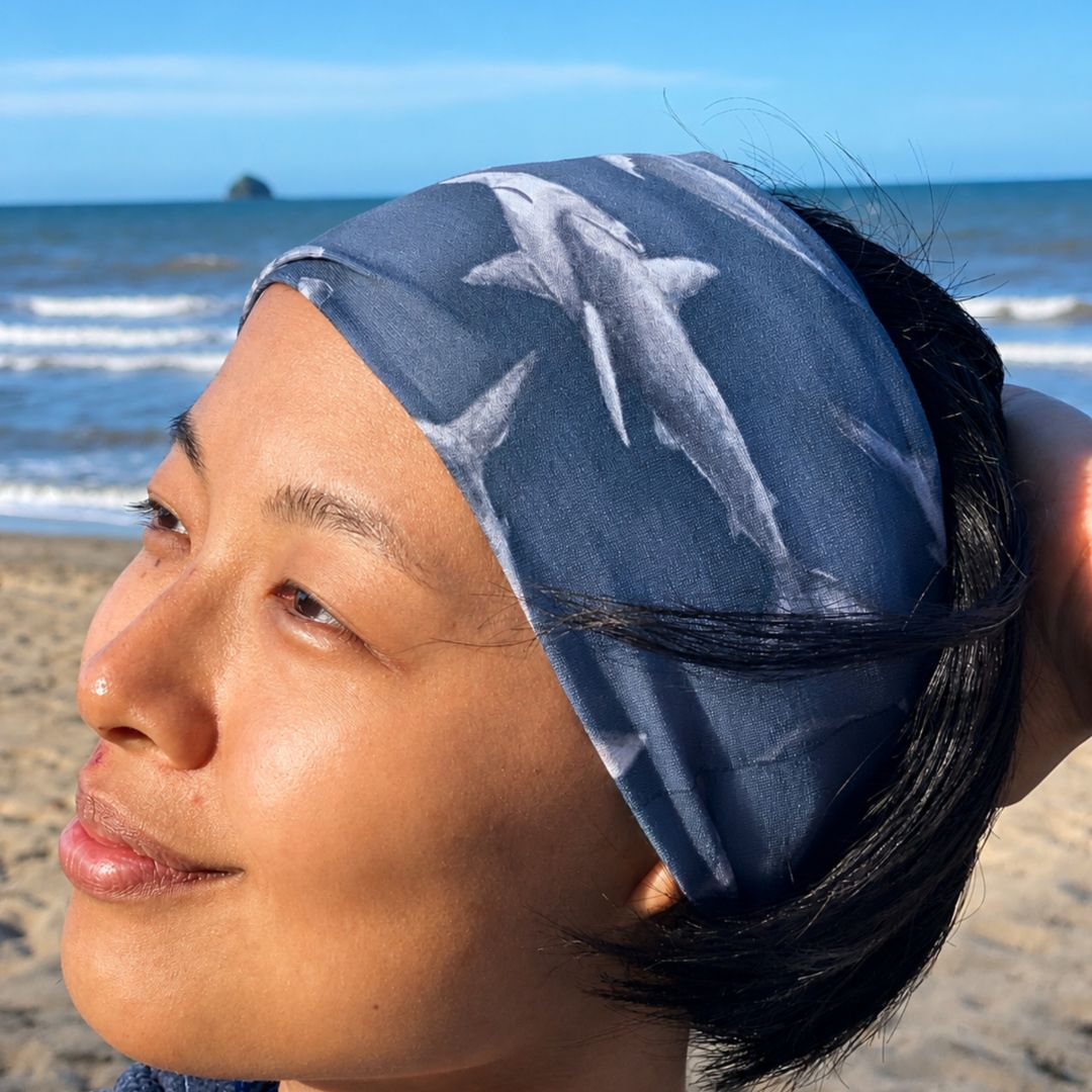 Person wearing a headband with shark design on a beach